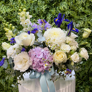 Bouquet of flowers with white, blue, and pink colours on a green background