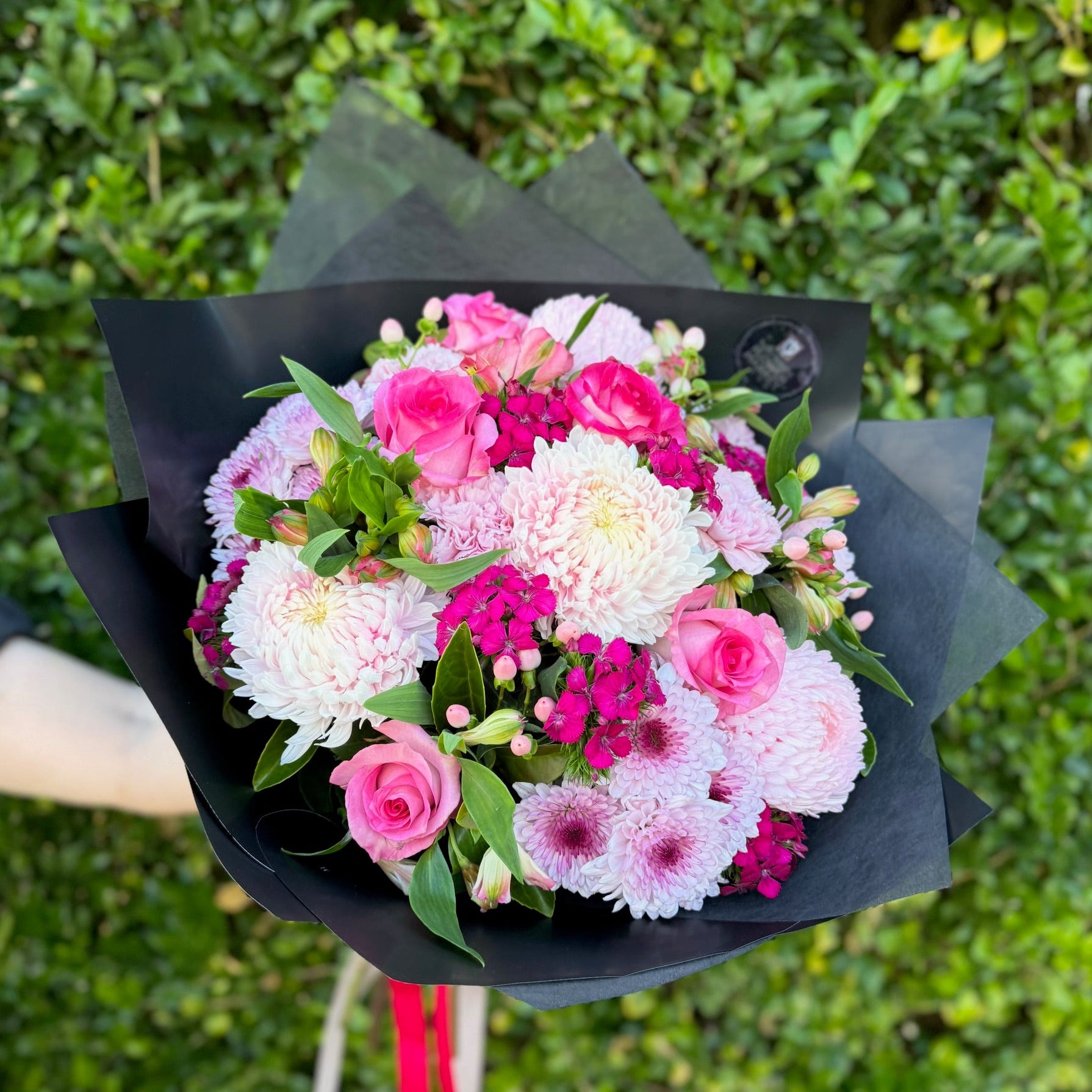A round floral bouquet featuring pink blooms