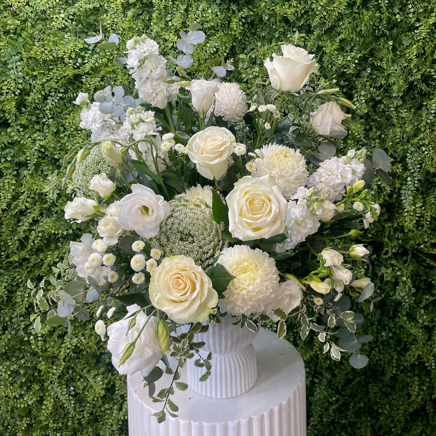 Bouquet of white flowers with greenery on a grassy background