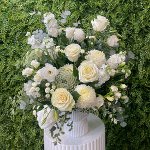 Bouquet of white flowers with greenery on a grassy background